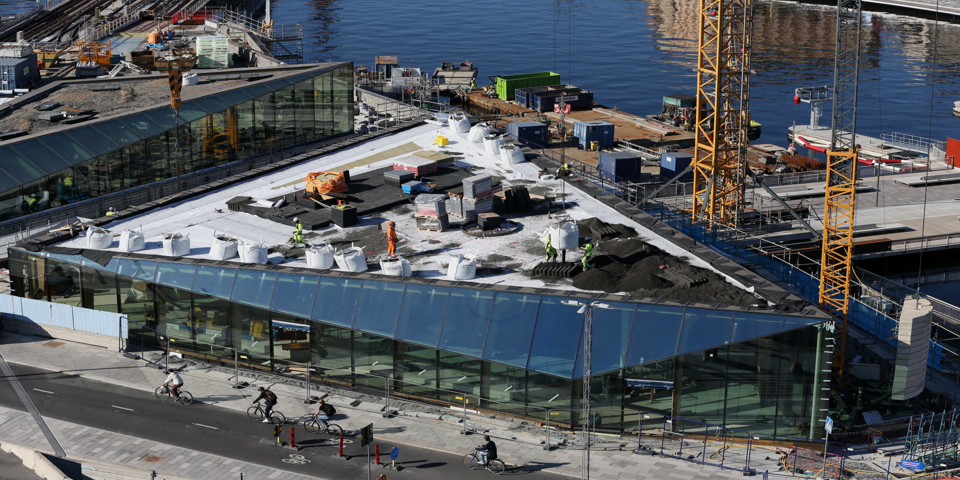 Byggmaterial och sandhögar på ett tak.